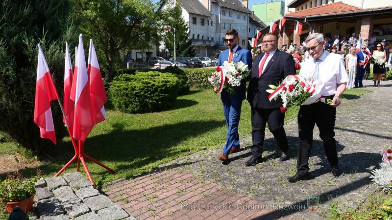 Kamil Glazer, Mateusz Zajdel,Walery Czarnecki składaja wiazanki kwiatów pod krzyżem