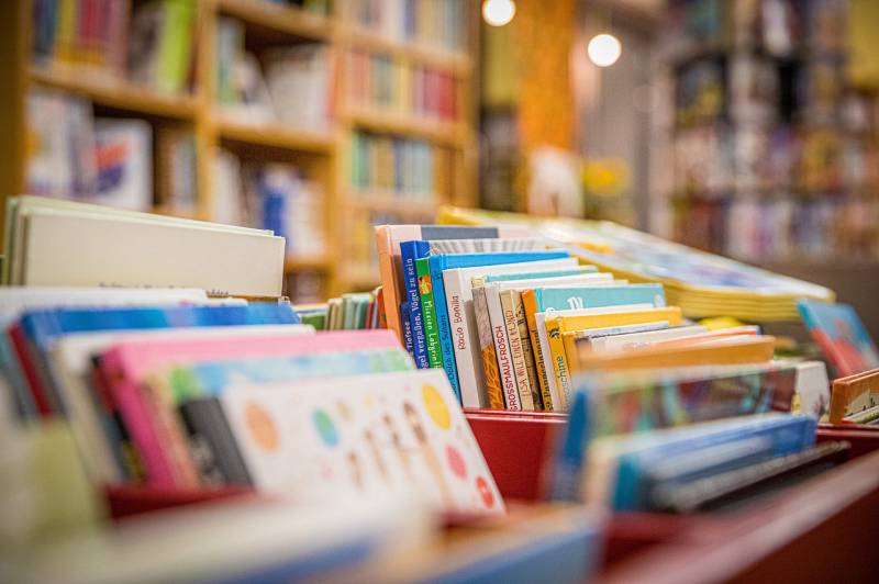 Półki z książkami w tle, na pierwszym planie ostrość na książki dla dzieci